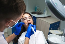 A dentist performing a root canal on a woman