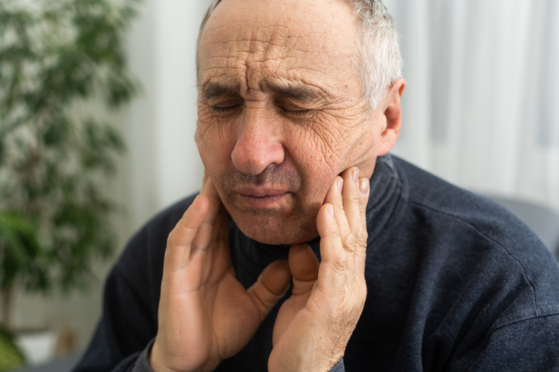 Patient holding their cheeks due to needing root canals